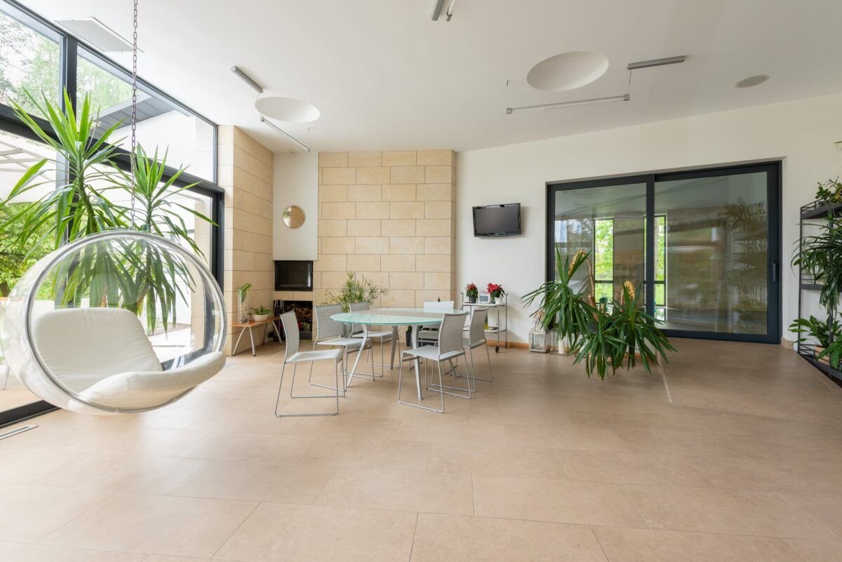 interior of spacious apartment with bubble chair and green plants