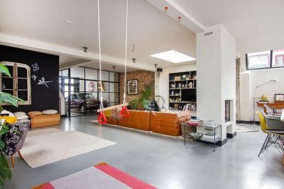 Un loft con garaje de cristal en el salón y decoración ecléctica